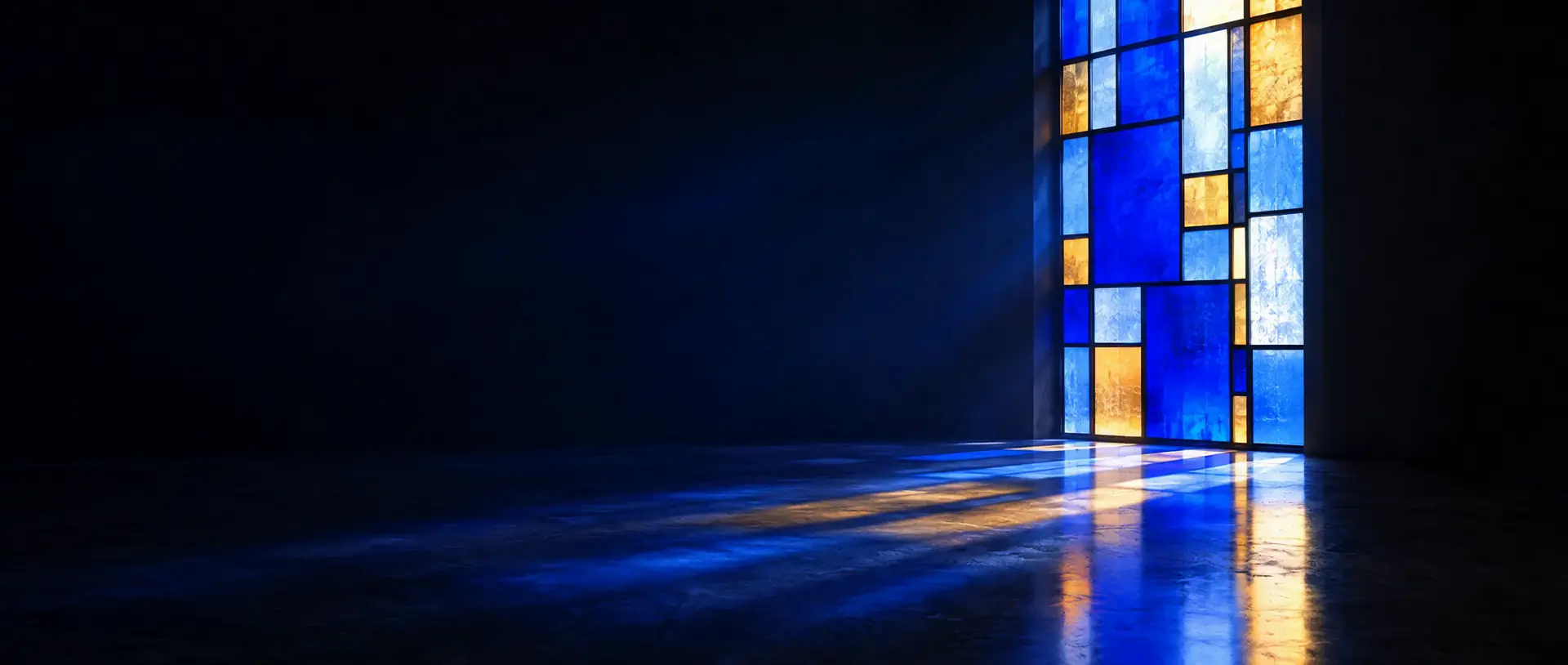 A Klein blue and amber stained-glass window glowing in a dark room, its light reflected across a polished floor